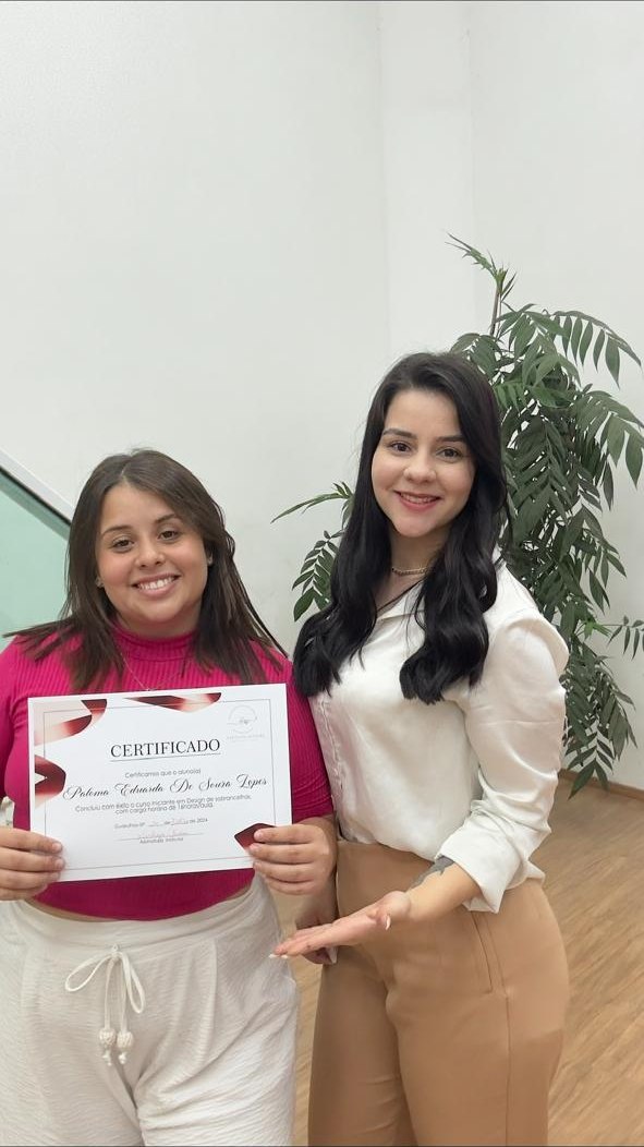 Karolyna ao lado de uma aluna com o certificado do curso individual